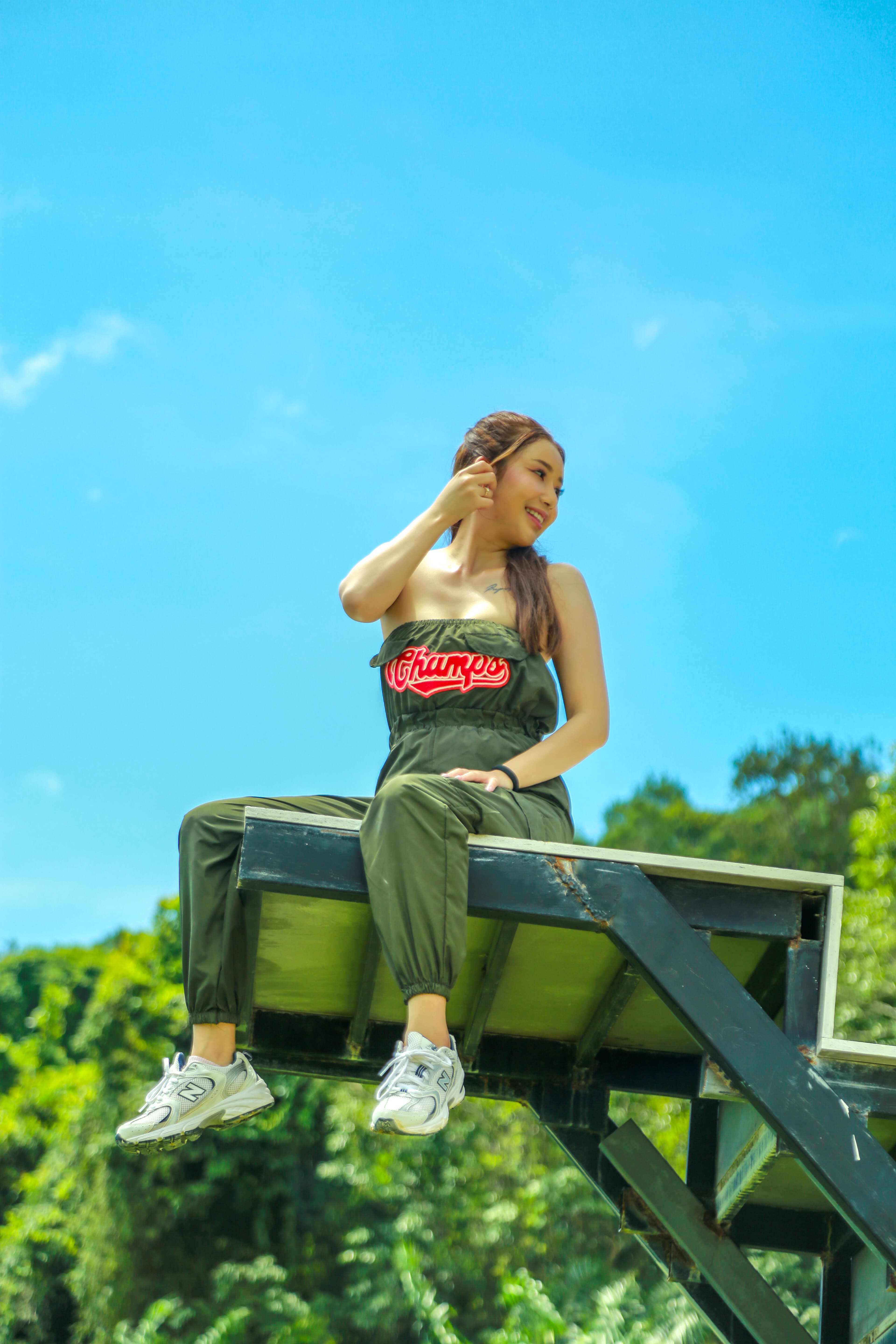 Guest sitting on a high zipline platform above the jungle canopy